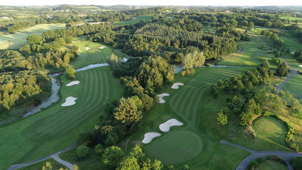 Stunning aerial view of lush golf course with manicured greens and scenic landscapes, perfect for relaxation and sport.