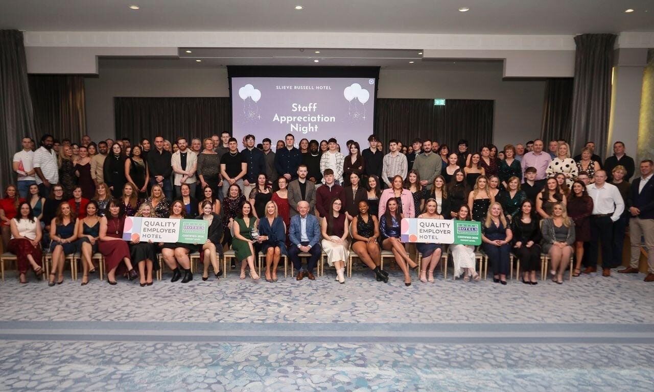 Spacious event room with guests at hotel ceremony, showcasing elegant decor and community spirit, perfect for gatherings.