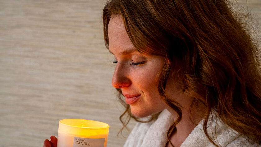 Guest enjoying a spa moment with a calming candle, creating a serene atmosphere at the hotel spa retreat.